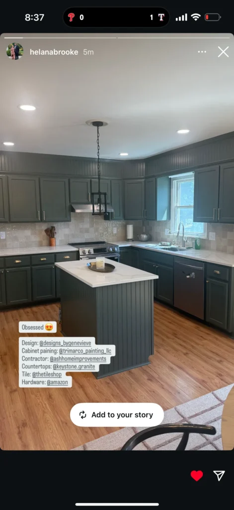 Modern kitchen with green cabinets, wooden flooring, and pendant lighting.